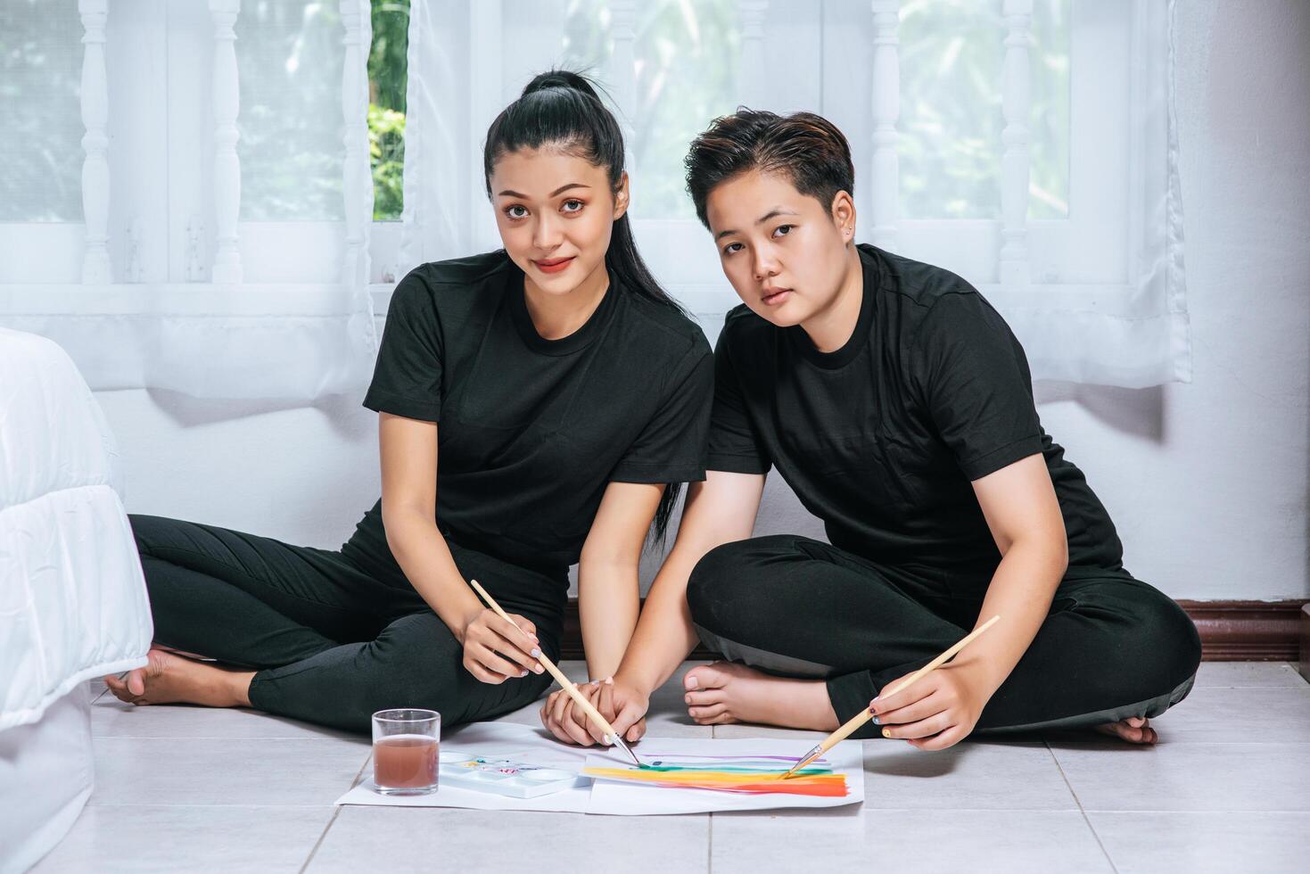 Female couples draw and paint on paper. photo