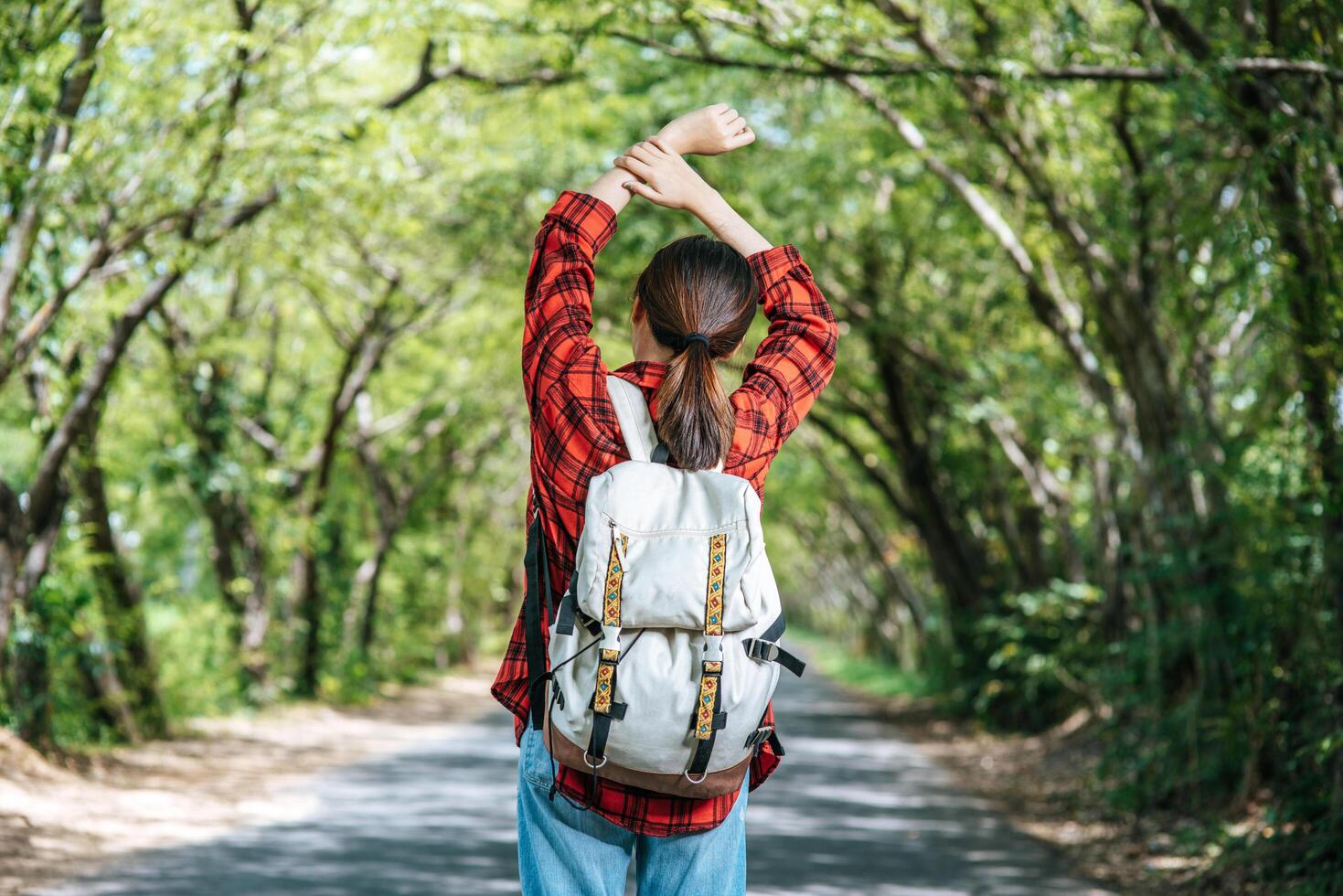 Female tourists carry a backpack and stand on the street. photo