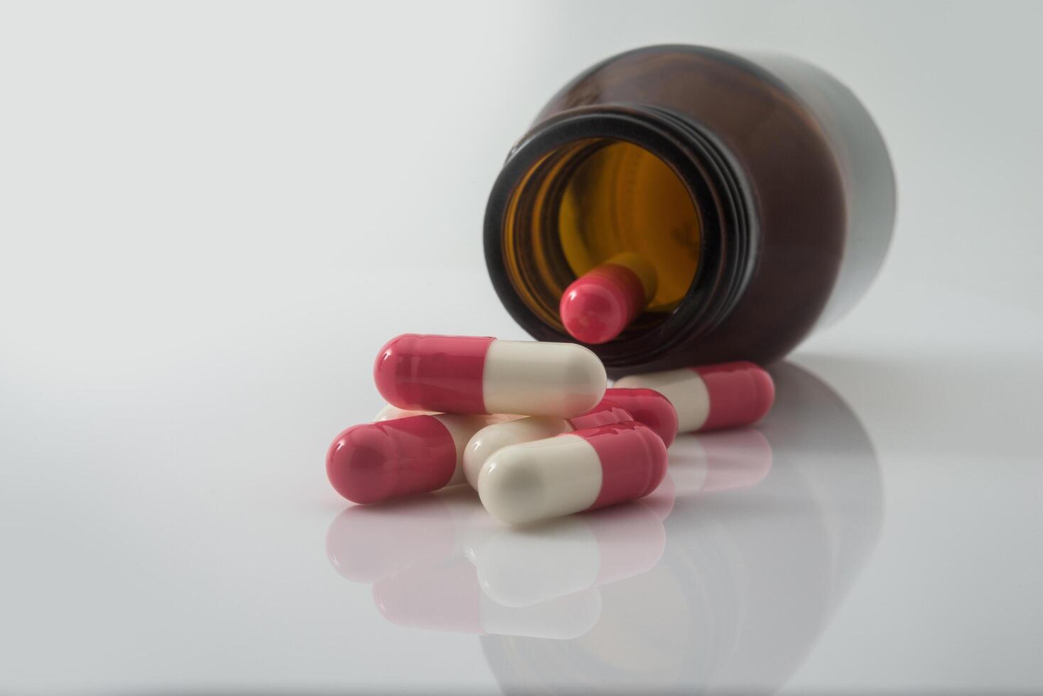 Medical pills spilling out of a toppled from pill bottle photo