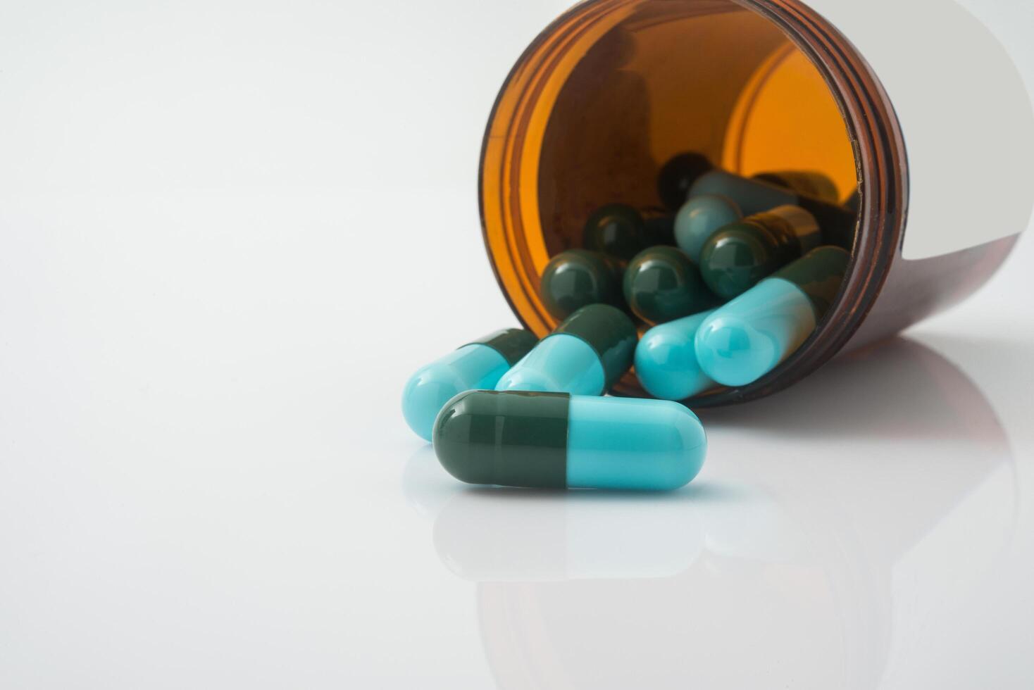 Medical pills spilling out of a toppled from pill bottle photo