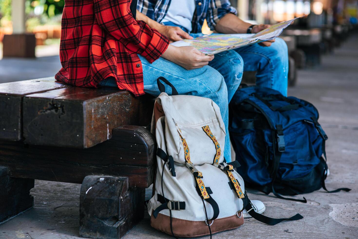 turistas masculinos y femeninos miran el mapa al lado del ferrocarril. foto