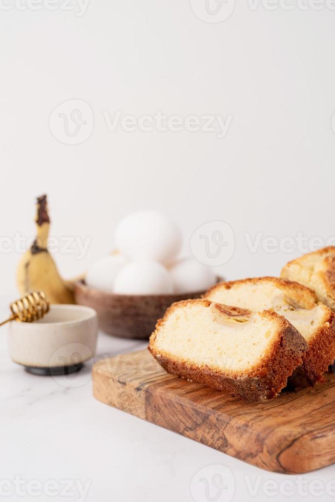 Front view of sliced banana bread on light concrete background photo