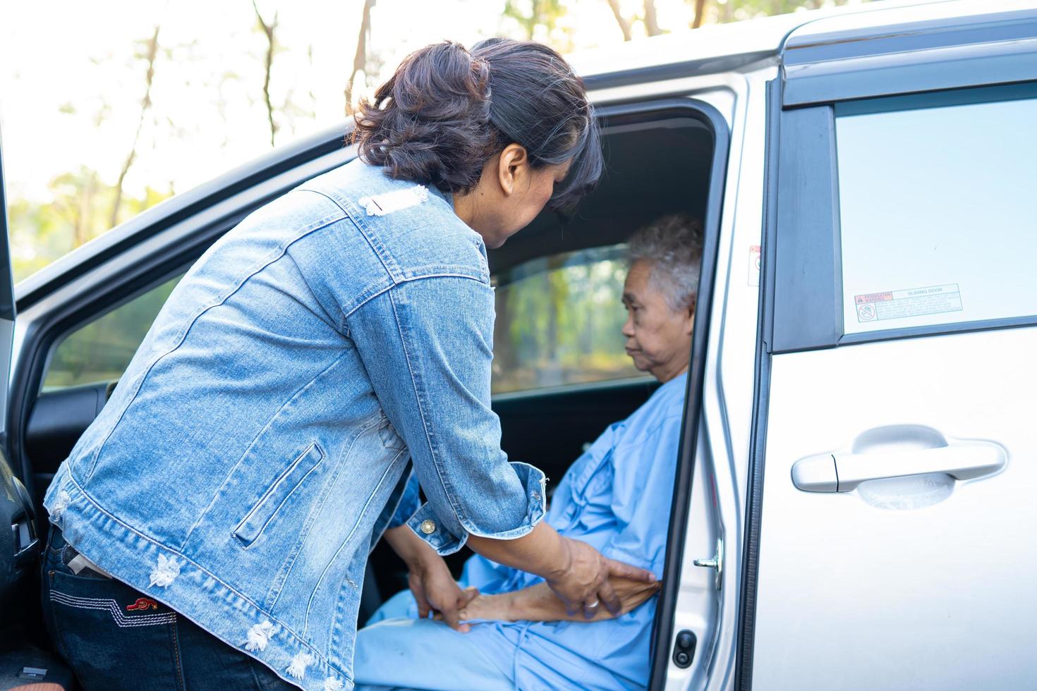 Help and support asian senior or elderly old lady woman patient get to her car, healthy strong medical concept. photo