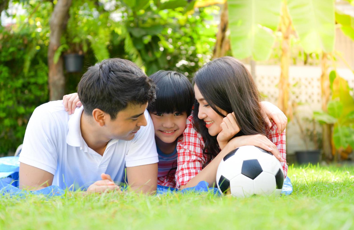 A happy young family spends time playing together in the garden at the front of house the vacation. photo