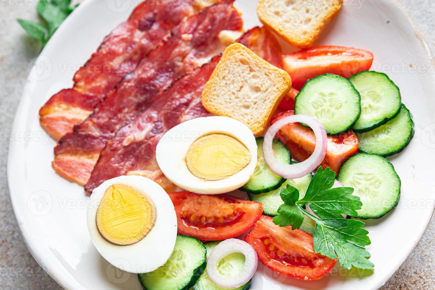 desayuno inglés tocino, huevo, tomate, pepino, pan tostado foto
