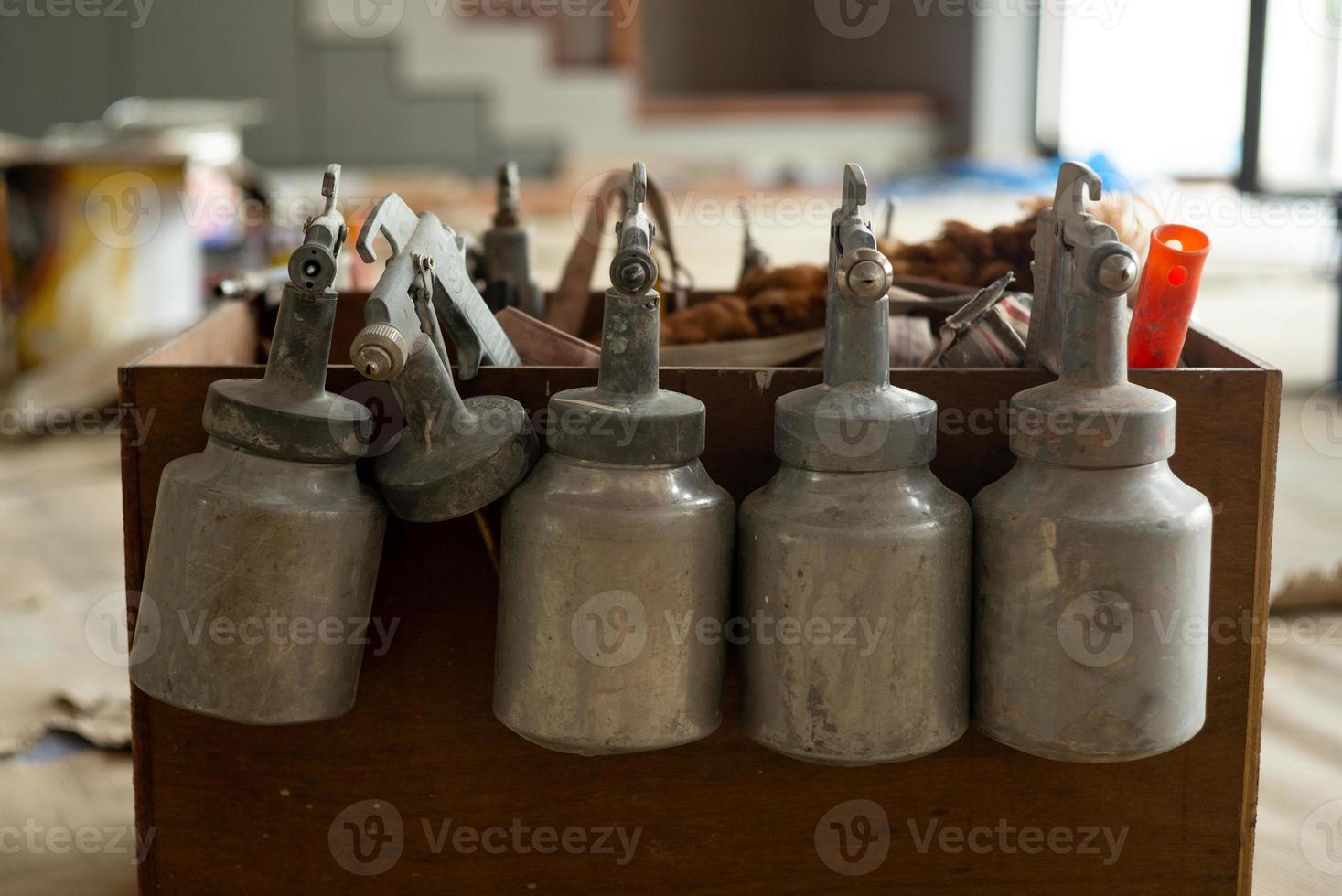 Closeup group of color sprayers hanging on the edge of wooden wagon standy for using. photo