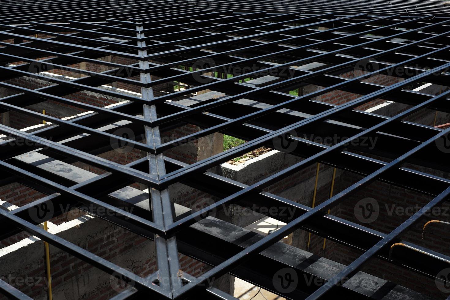 Low angle view of metal structure of roof at the construction site with bricklayers wall below photo