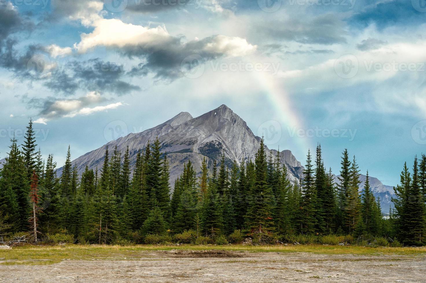 Mount Rundle with pine trees and rainbow in the blue sky photo