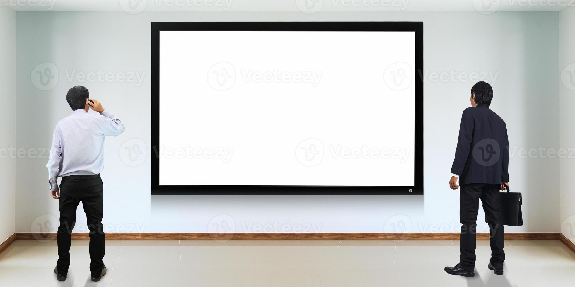 Successful businessman standing in front of TV screen photo