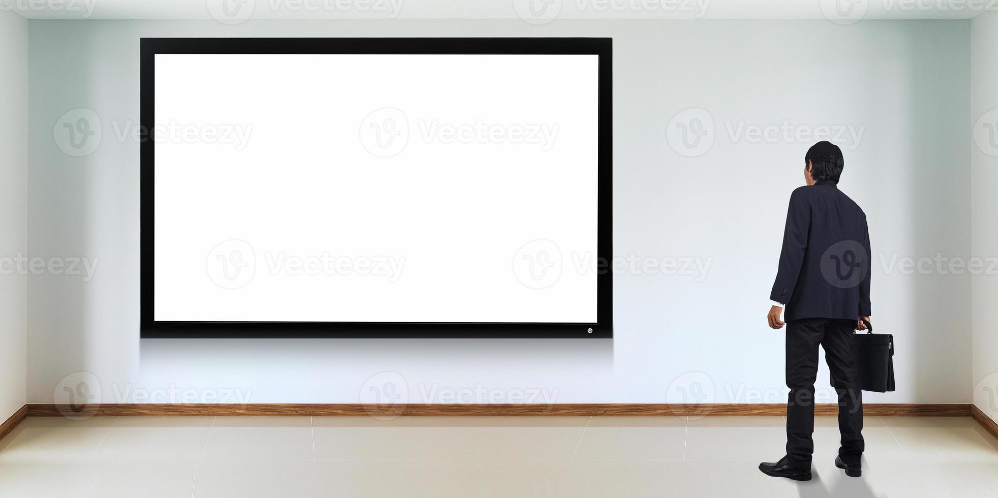 Successful businessman standing in front of TV screen photo