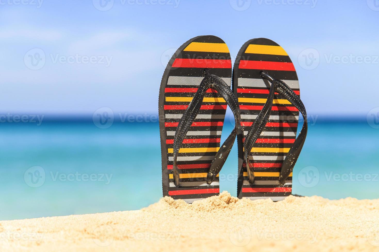 Flip flops on the sandy beach photo