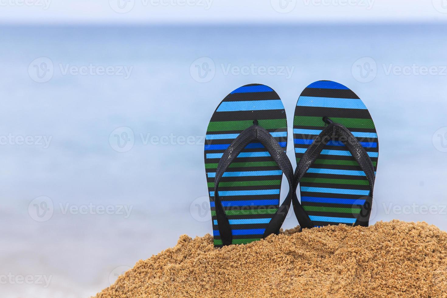 Flip flops on the sandy beach photo