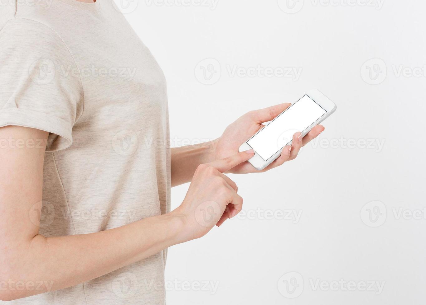 La mujer muestra la pantalla en blanco del teléfono móvil, la mano apunta al dispositivo, la pantalla celular en blanco foto
