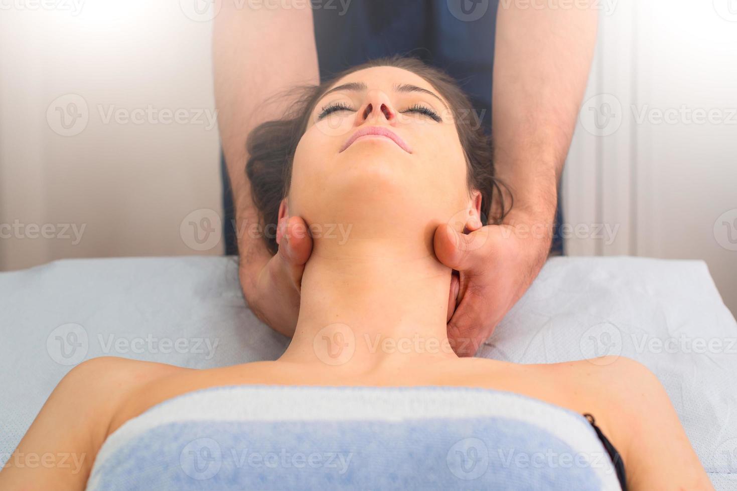 Terapeuta masajeando el cuello de la mujer por un profesional. foto