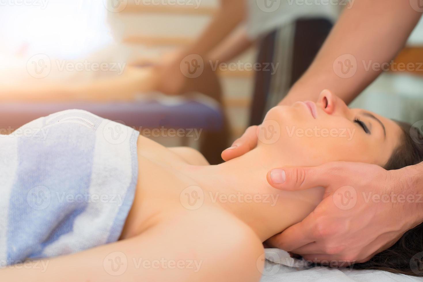 terapeuta masajeando el cuello de la mujer foto