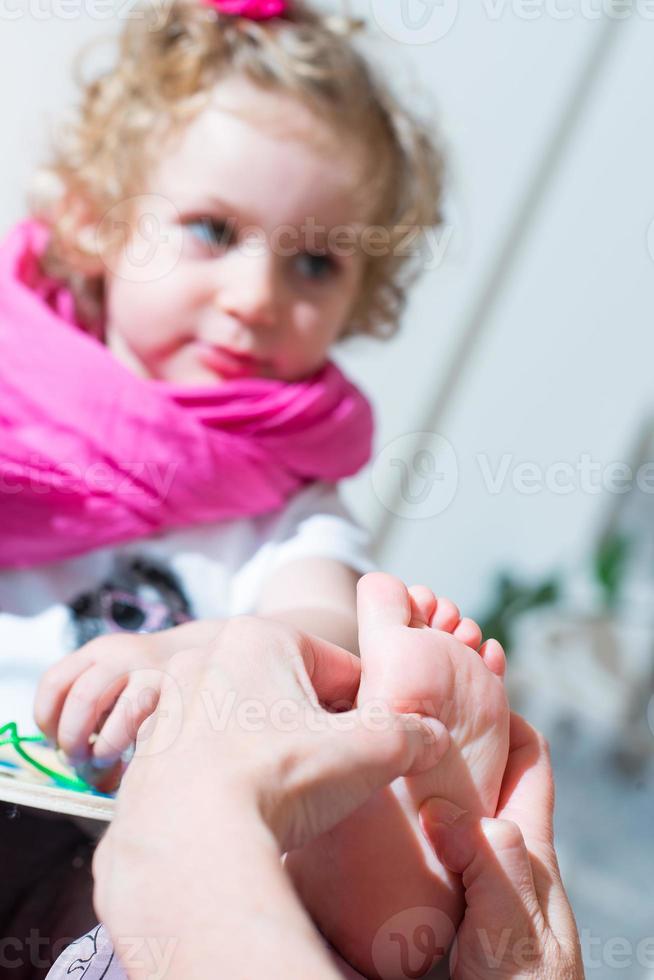 Reflexology foot massage to a female child photo