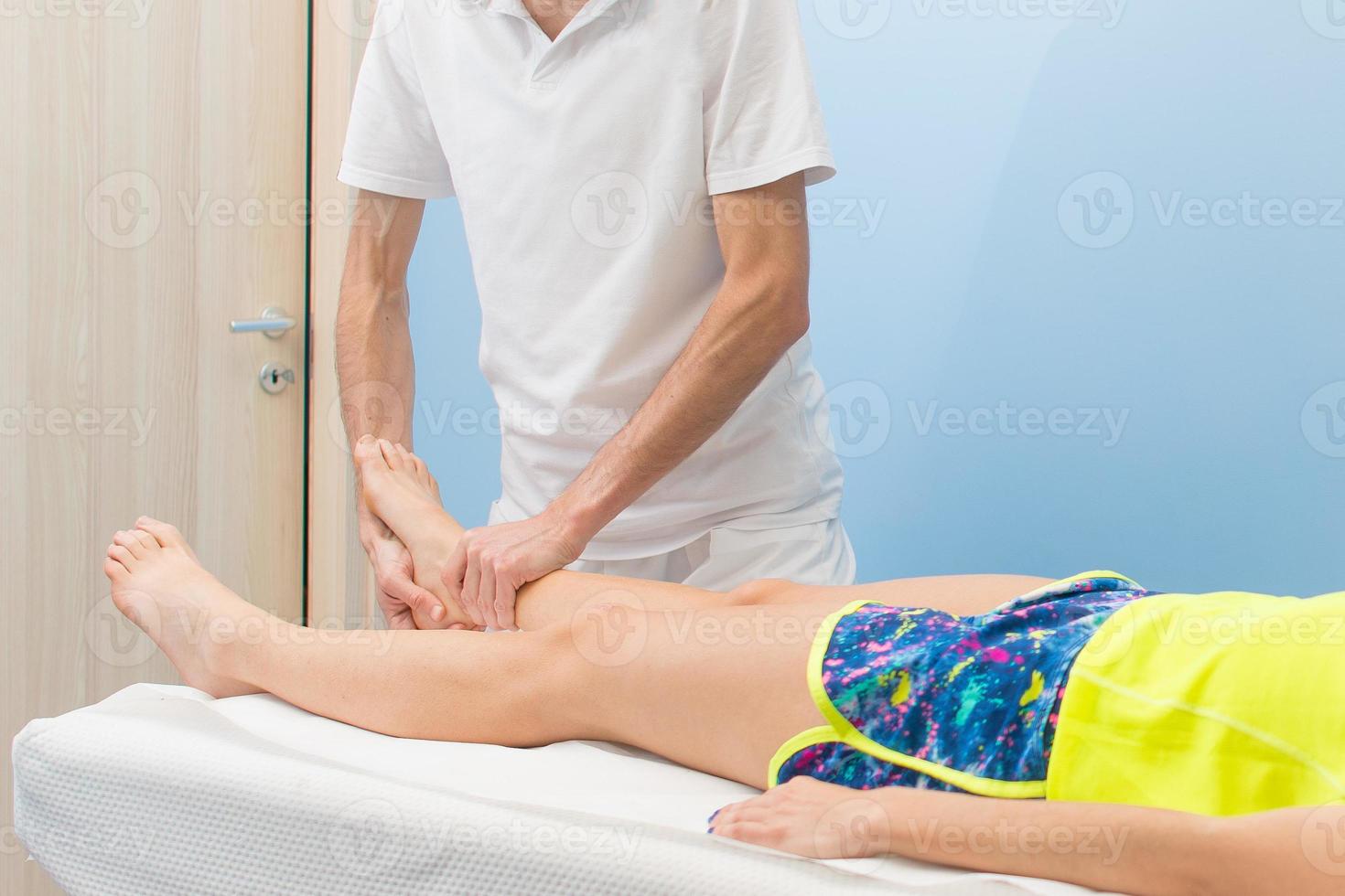 Physiotherapist practices an ankle mobilization photo