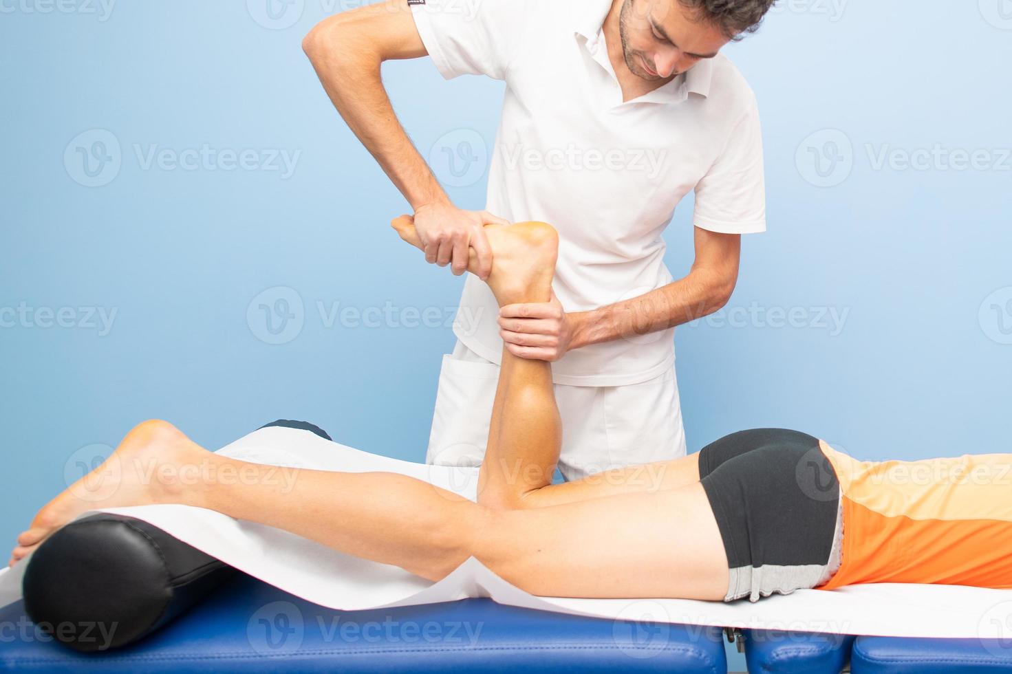 práctica de fisioterapia movilización tibio-tarsal a un atleta foto