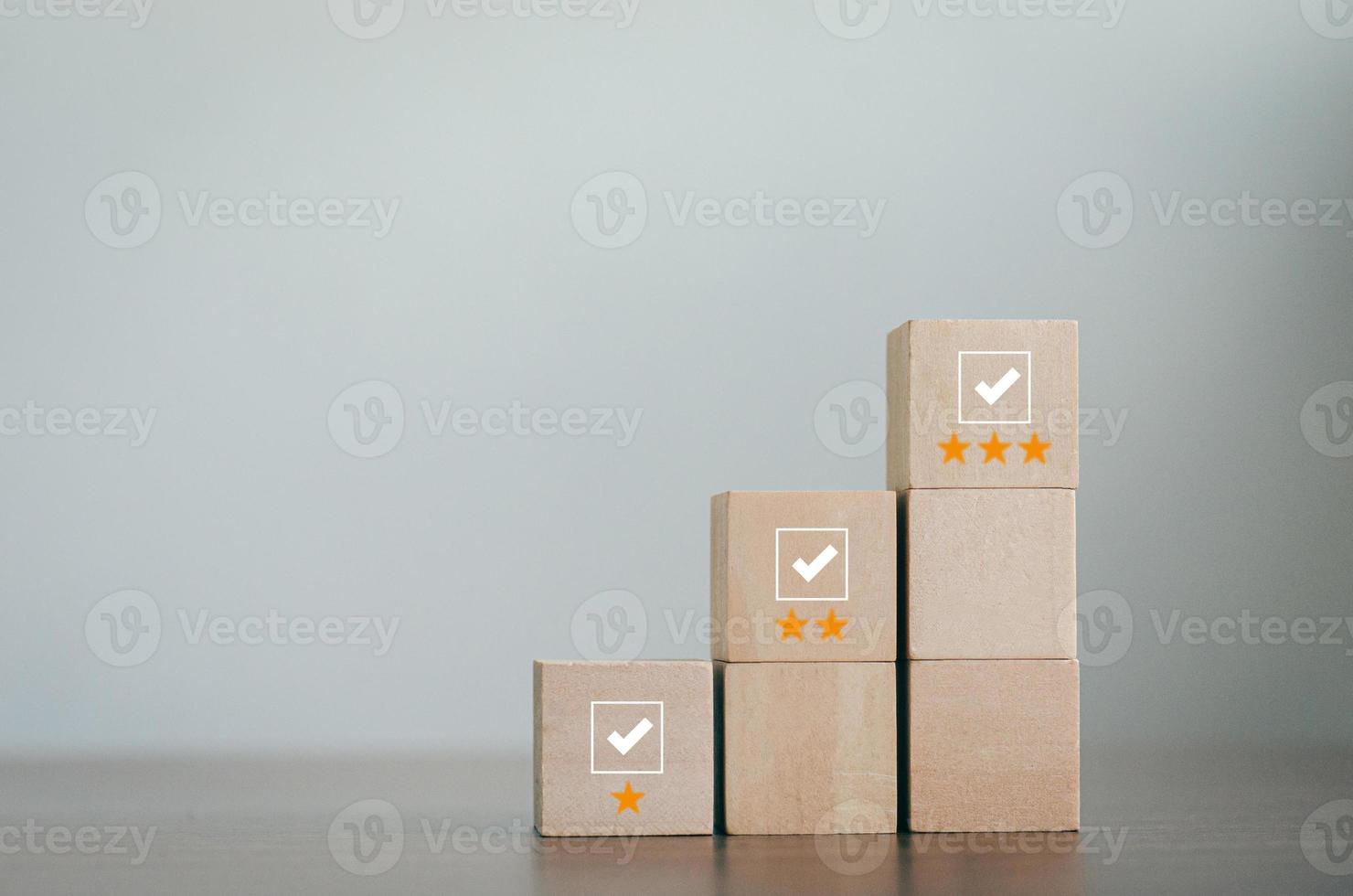 wooden block in review concept Survey and Assessment Concept The wooden blocks are arranged in a pyramid. cube with check mark icon on wooden block Gray background with copy space photo