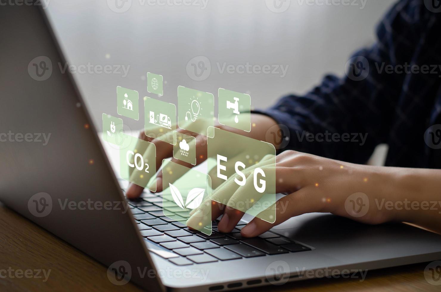 Young man sitting using a computer to analyze ESG, environment, conservation, society, governance, close to the computer screen in business investment strategy concept. photo