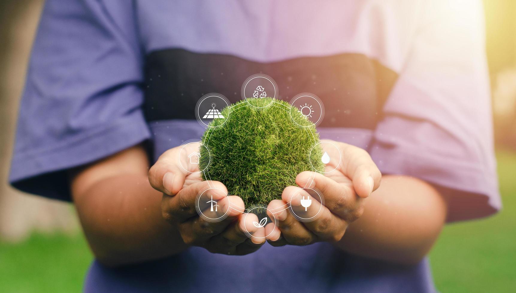 tierra en el tiempo de la naturaleza en manos humanas con el icono de recursos energéticos. día de la Tierra. concepto de ahorro de energía. foto