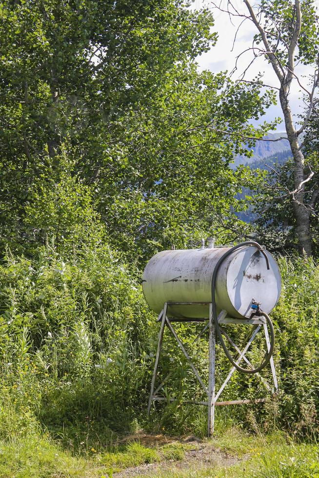 Depósito de gasolina o dispensador de agua en el prado en Noruega. foto