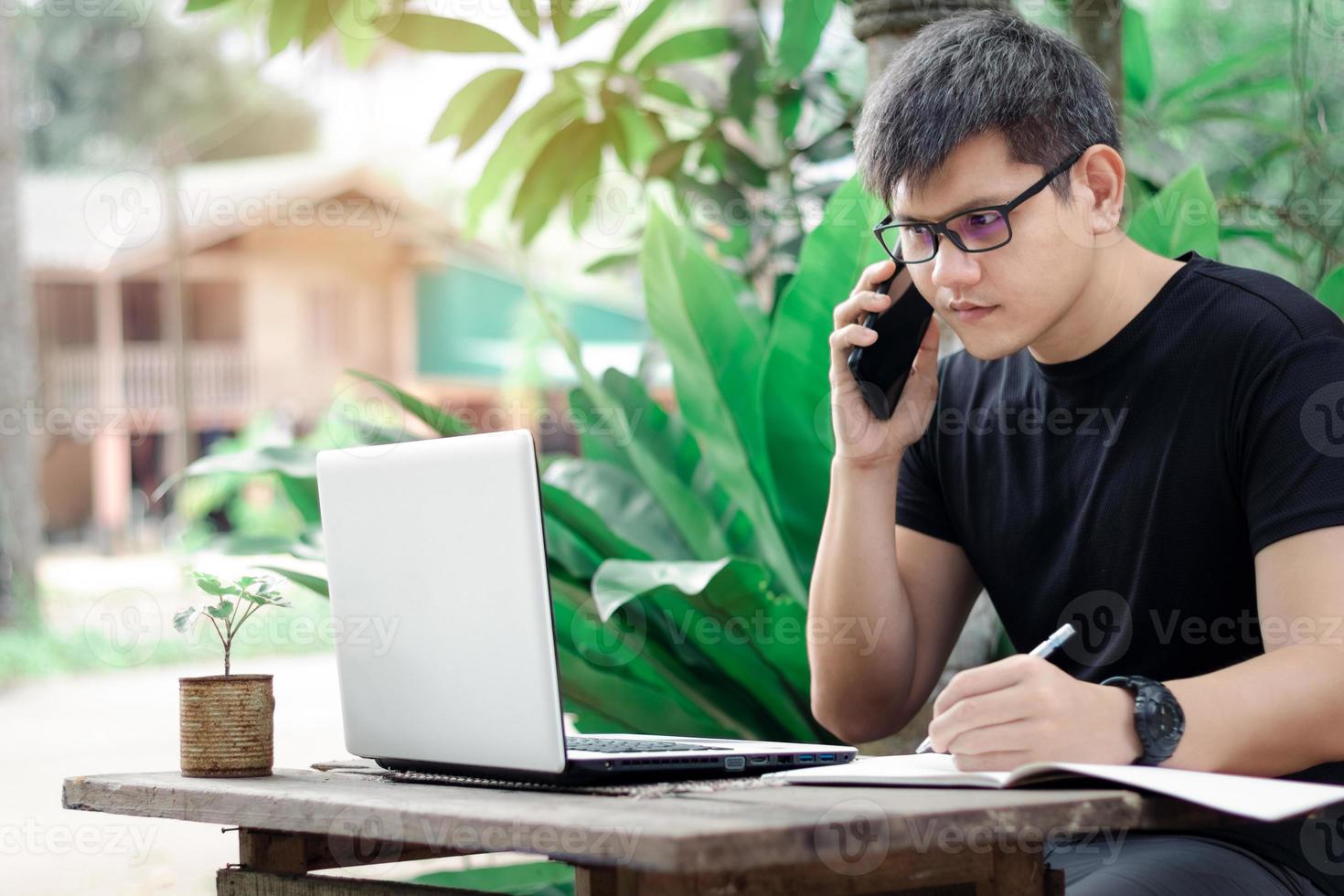 Young business man talking on the phone on the weekend, male freelancer working with laptop freelance surfing online, Business man working at home, dream job, online purchase sale. photo