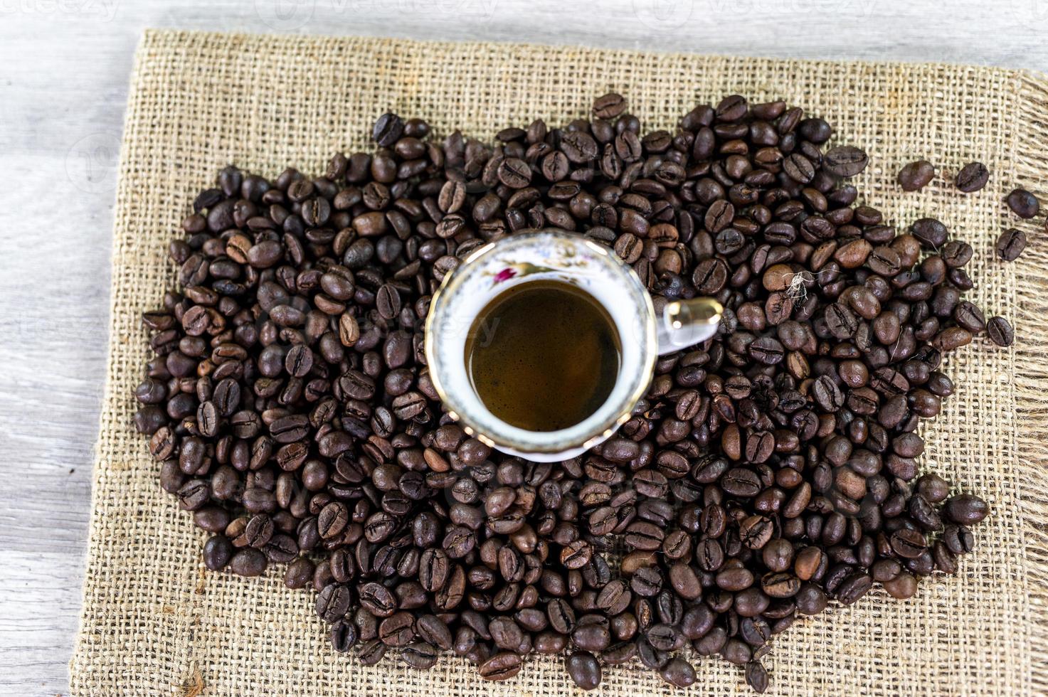 taza de café en medio de granos de café foto