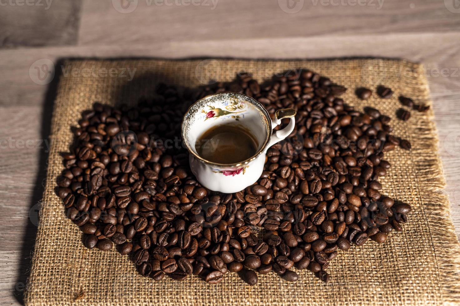 cup of coffee amidst coffee beans photo