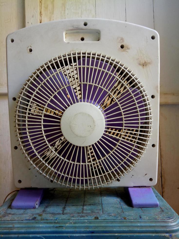 back view of old white fan on white wooden wall background photo