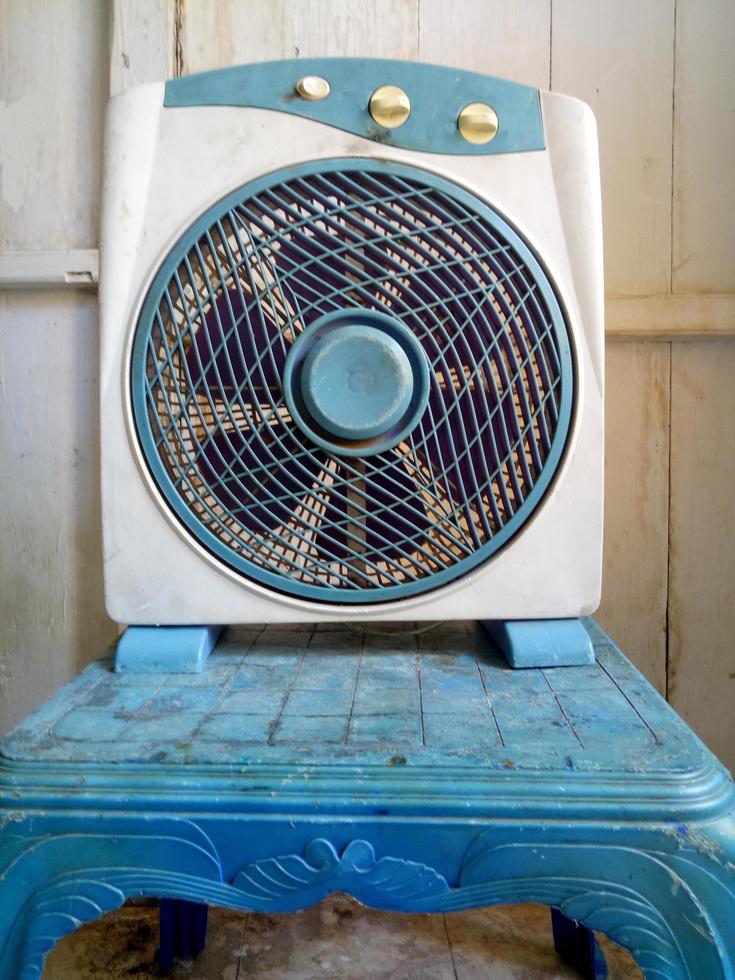 Viejo ventilador blanco sobre fondo de pared de madera blanca foto