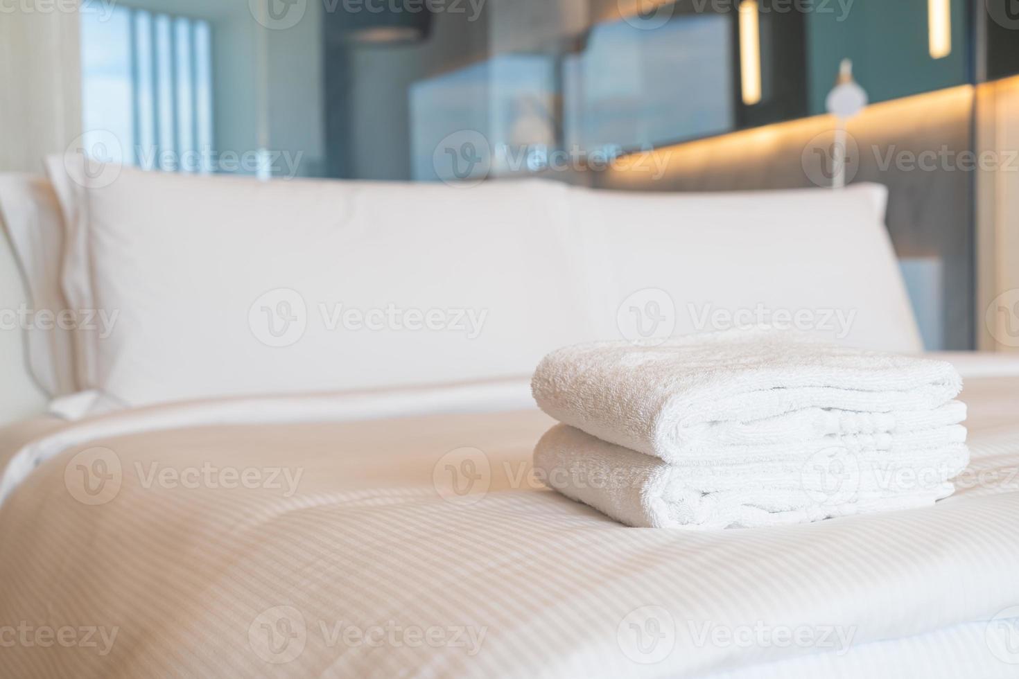 white shower towel on bed photo