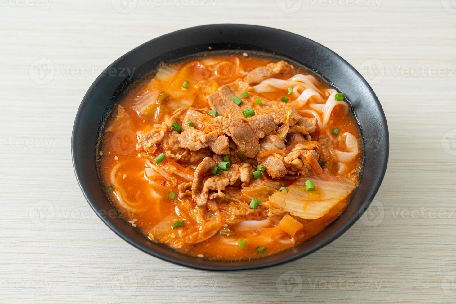 Korean udon ramen noodles with pork in kimchi soup photo