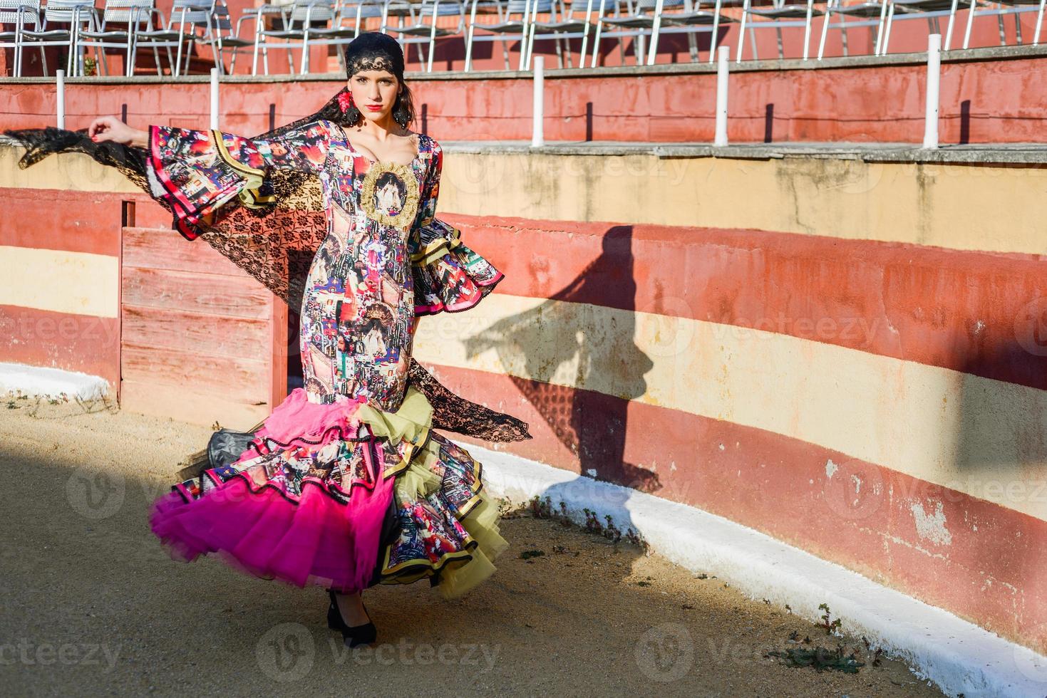 Woman, model of fashion, wearing a dress in a bullring photo