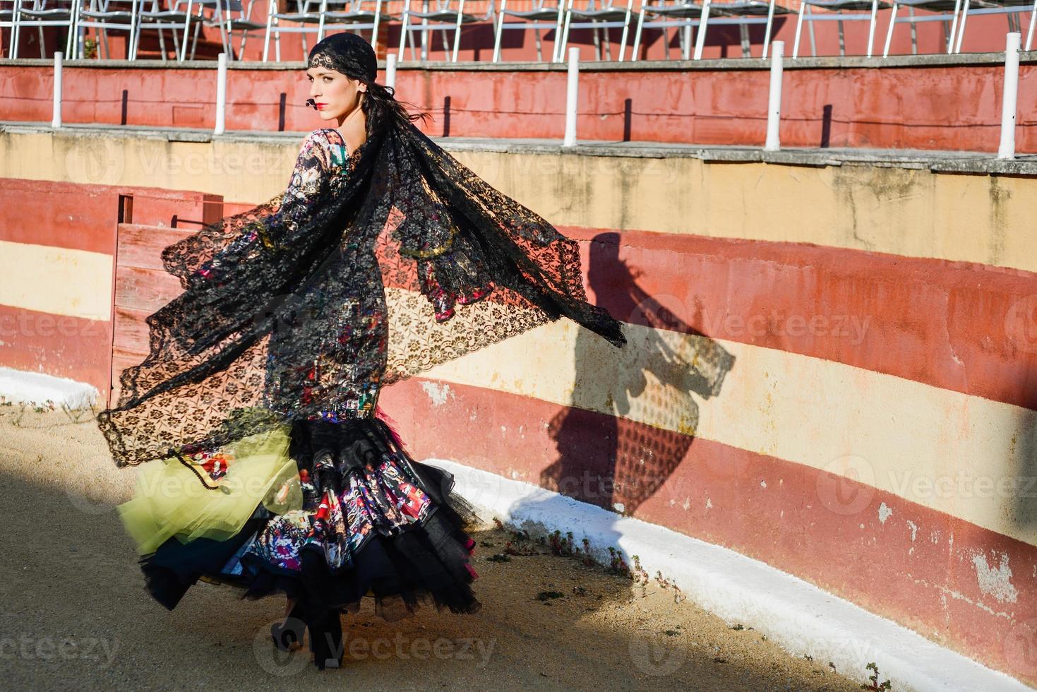 Woman, model of fashion, wearing a dress in a bullring photo