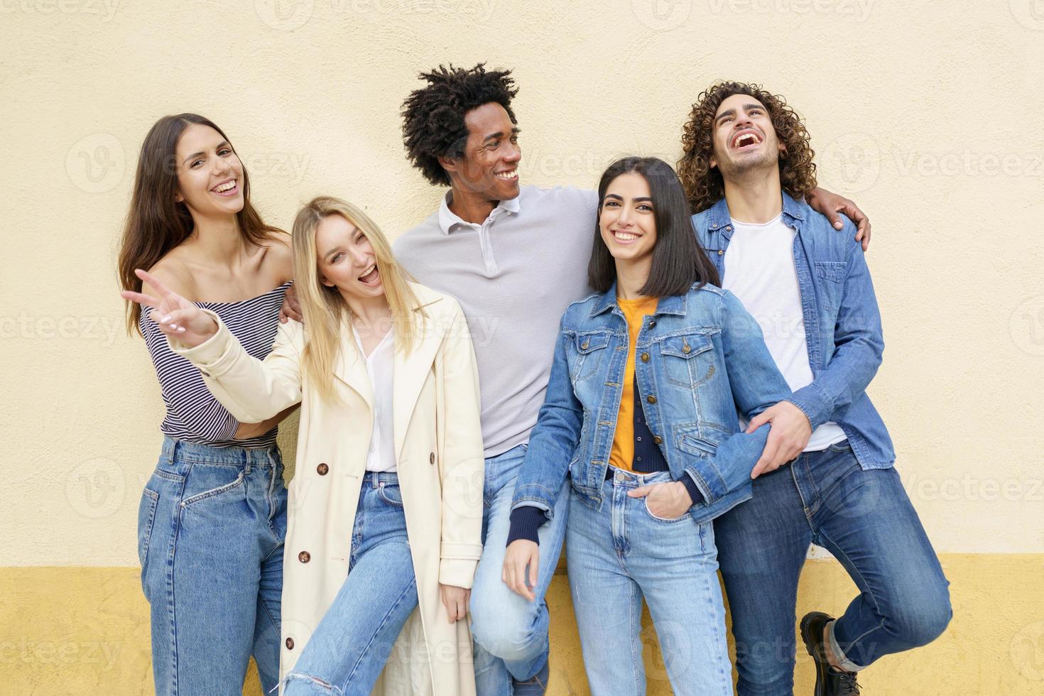 Multi-ethnic group of friends posing while having fun and laughing together photo