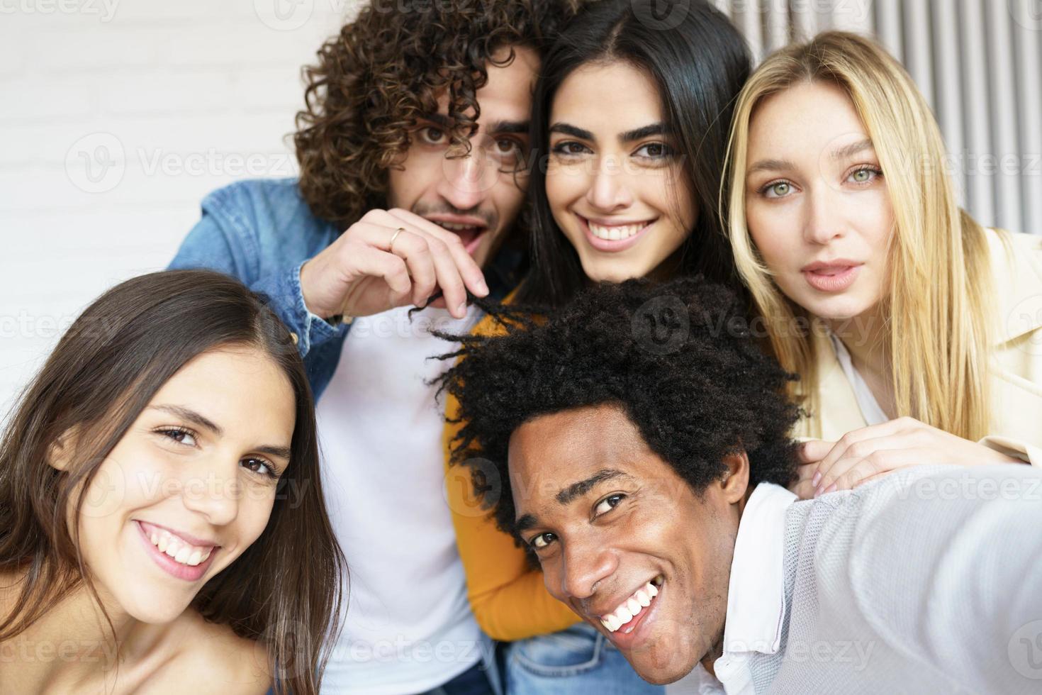 Grupo multiétnico de amigos tomando un selfie juntos mientras se divierten al aire libre. foto