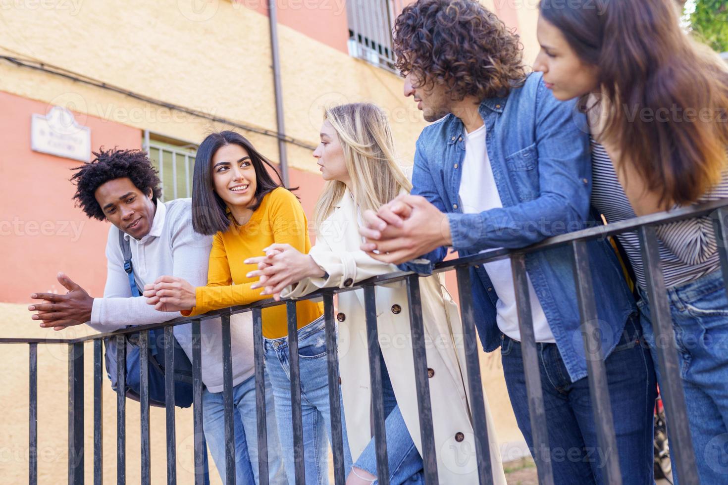 grupo multirracial de jóvenes hablando juntos en la calle. foto