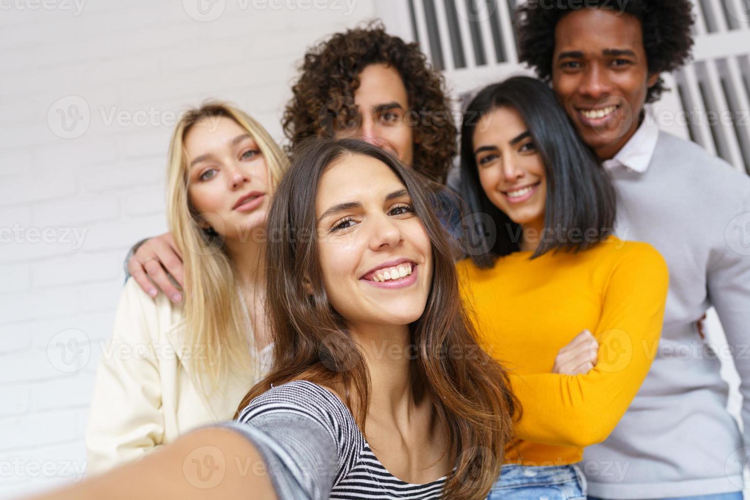 Grupo multiétnico de amigos tomando un selfie juntos mientras se divierten al aire libre. foto