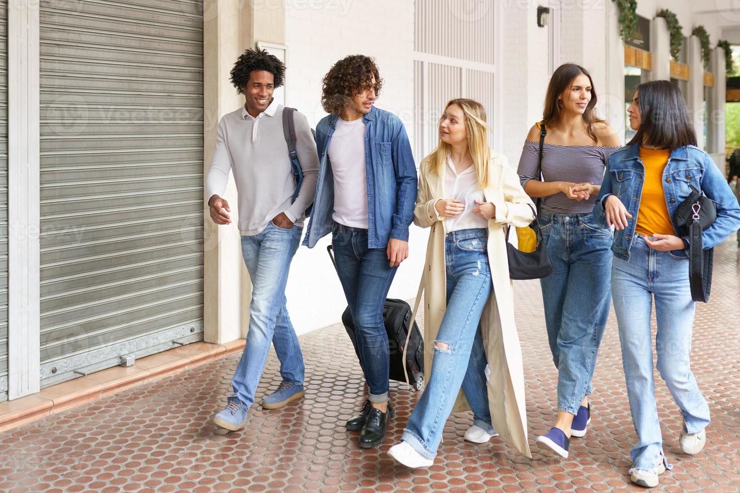 grupo multiétnico de amigos caminando juntos en la calle. foto