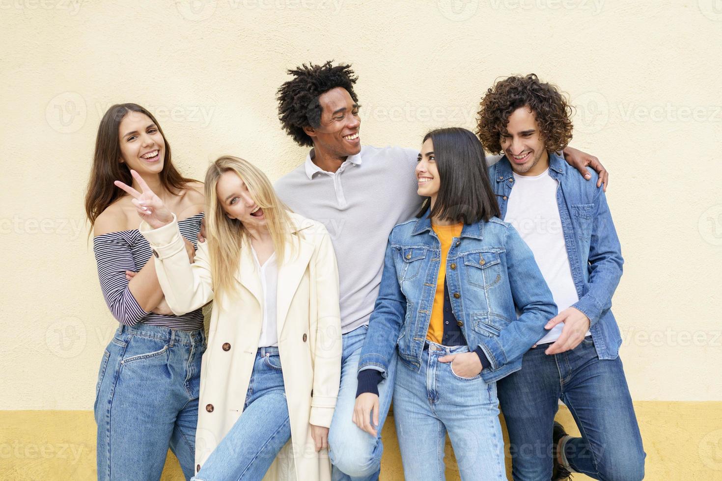 Grupo multiétnico de amigos posando mientras se divierten y ríen juntos foto