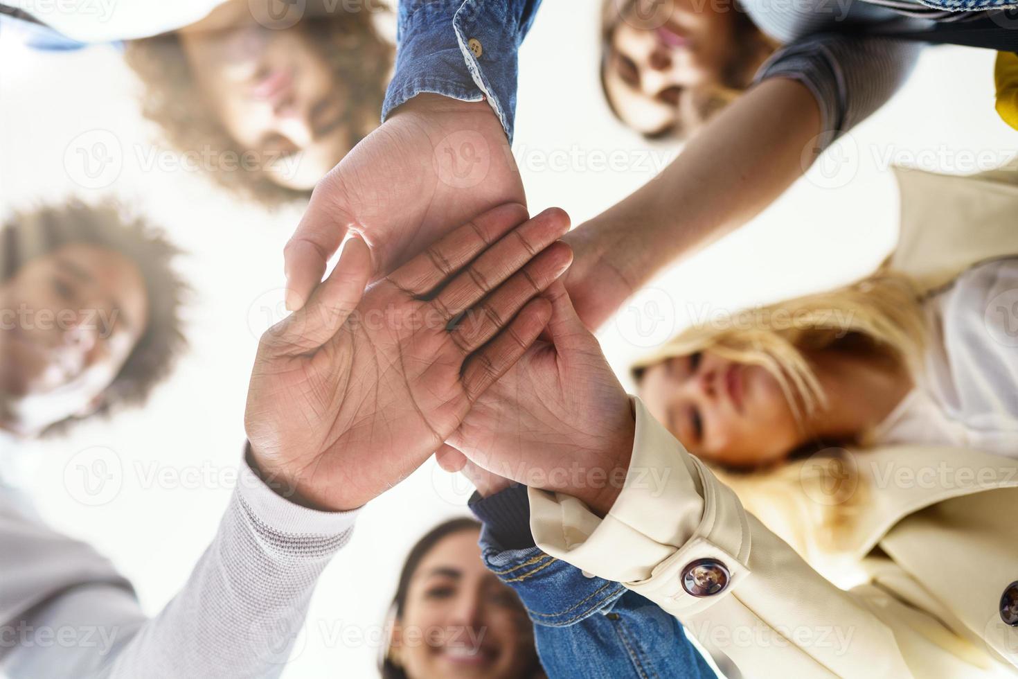 Multi-ethnic group of people putting their hands together. photo