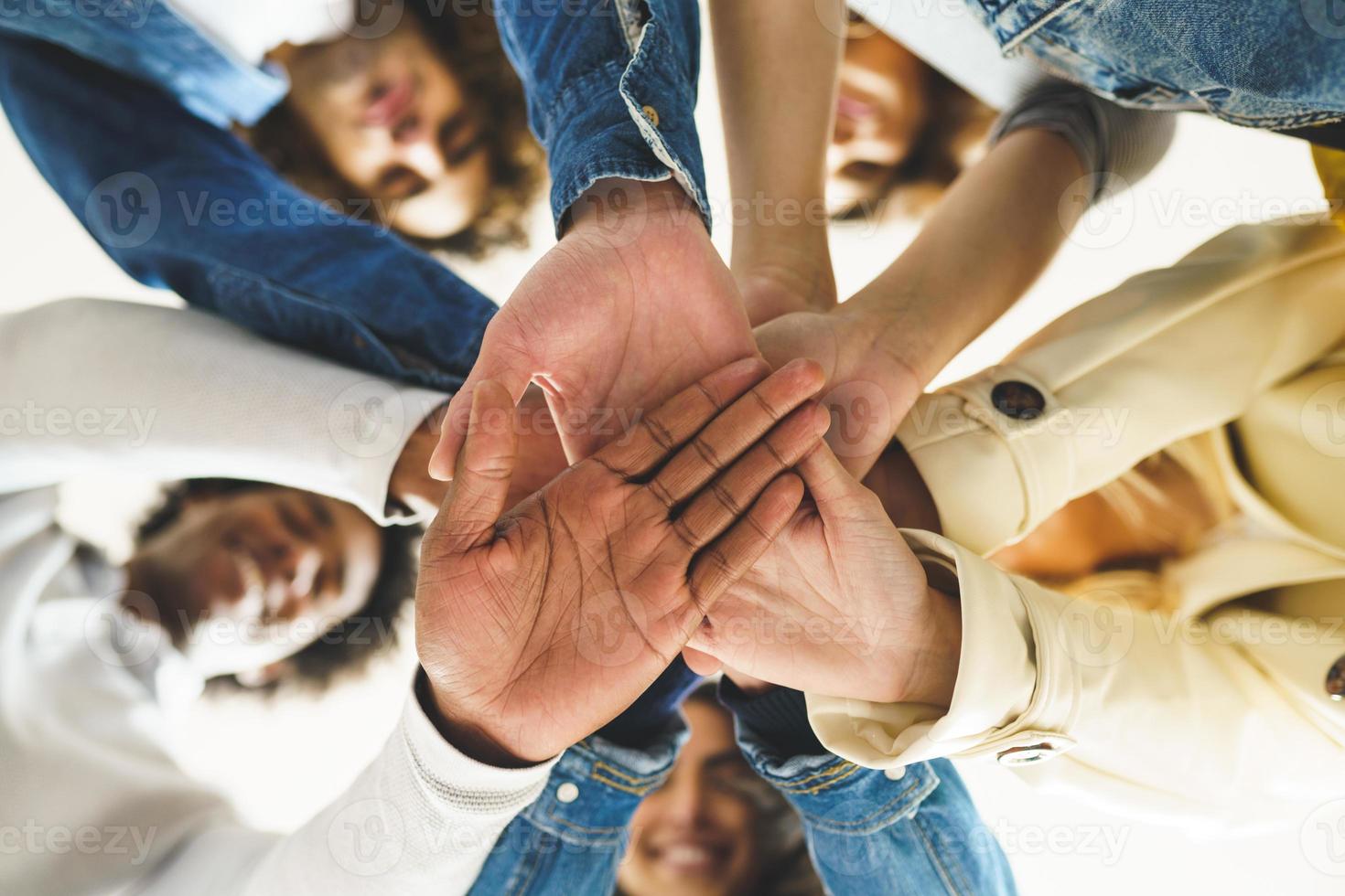 manos de un grupo multiétnico de amigos se unieron como muestra de apoyo y trabajo en equipo. foto