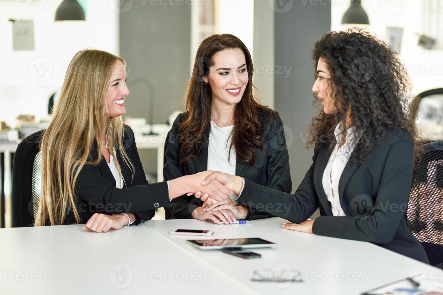 tres mujeres empresarias un apretón de manos en una oficina moderna foto