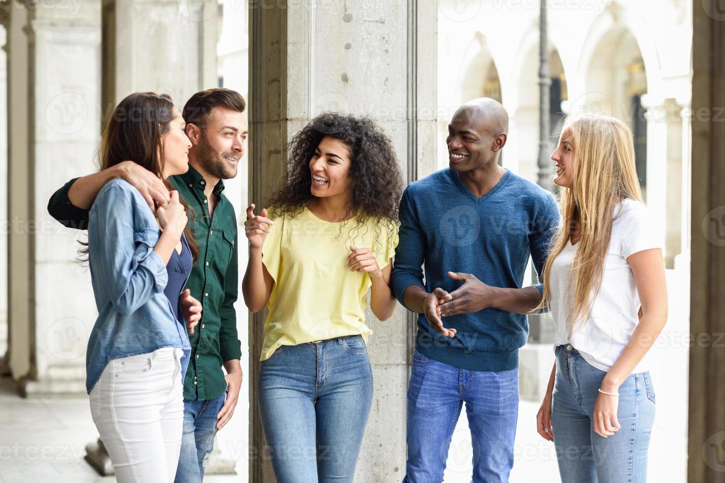 Multi-ethnic group of friends having fun together in urban background photo