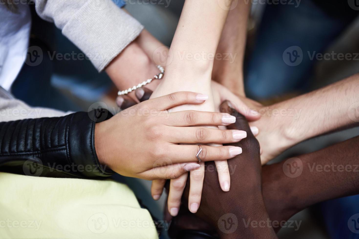 Top view of young people putting their hands together. photo