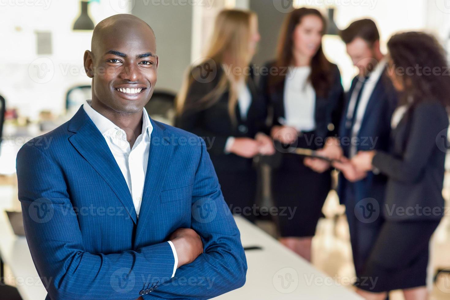 Líder empresario en la oficina moderna con empresarios que trabajan en segundo plano. foto