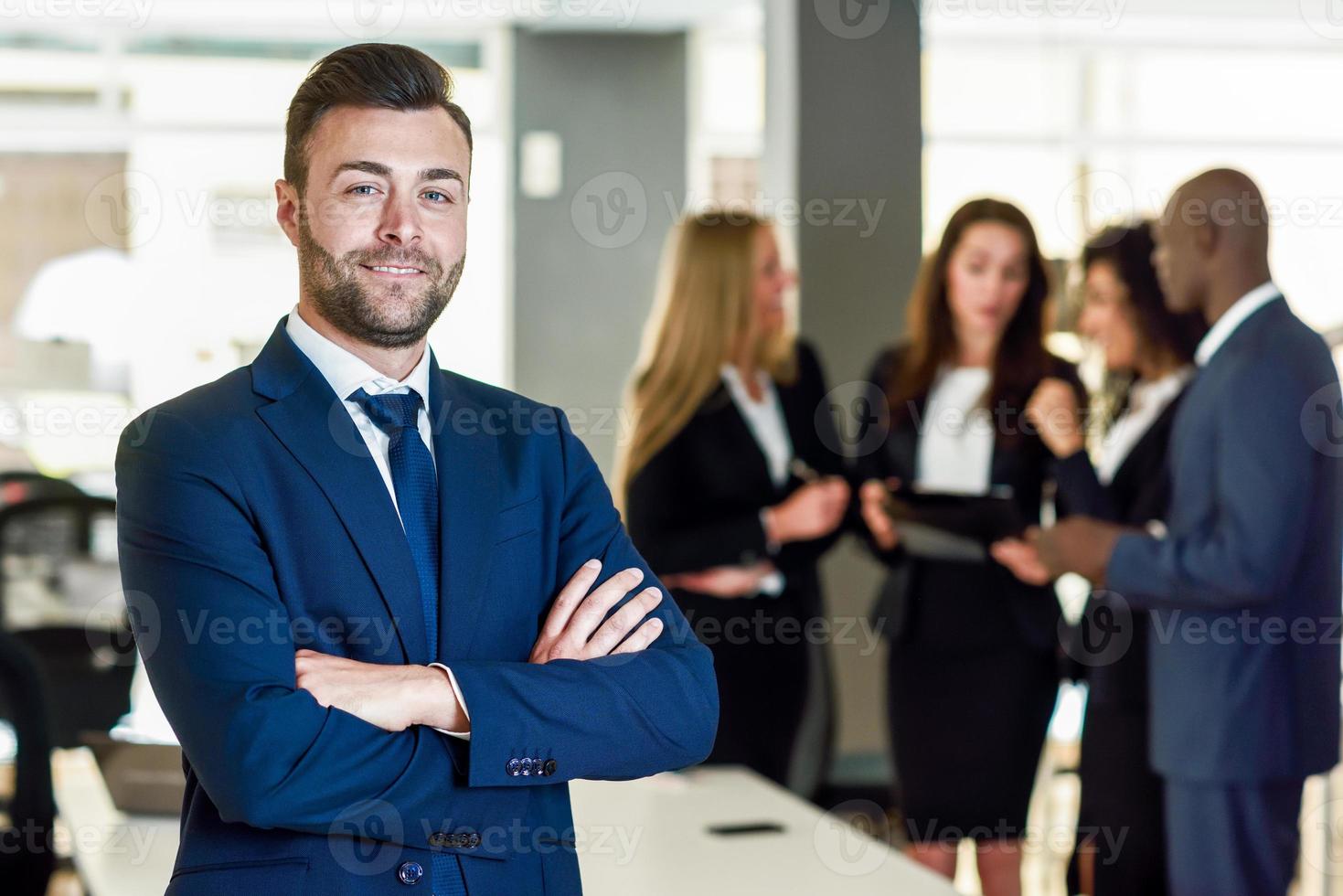 Líder empresario en la oficina moderna con empresarios que trabajan en segundo plano. foto