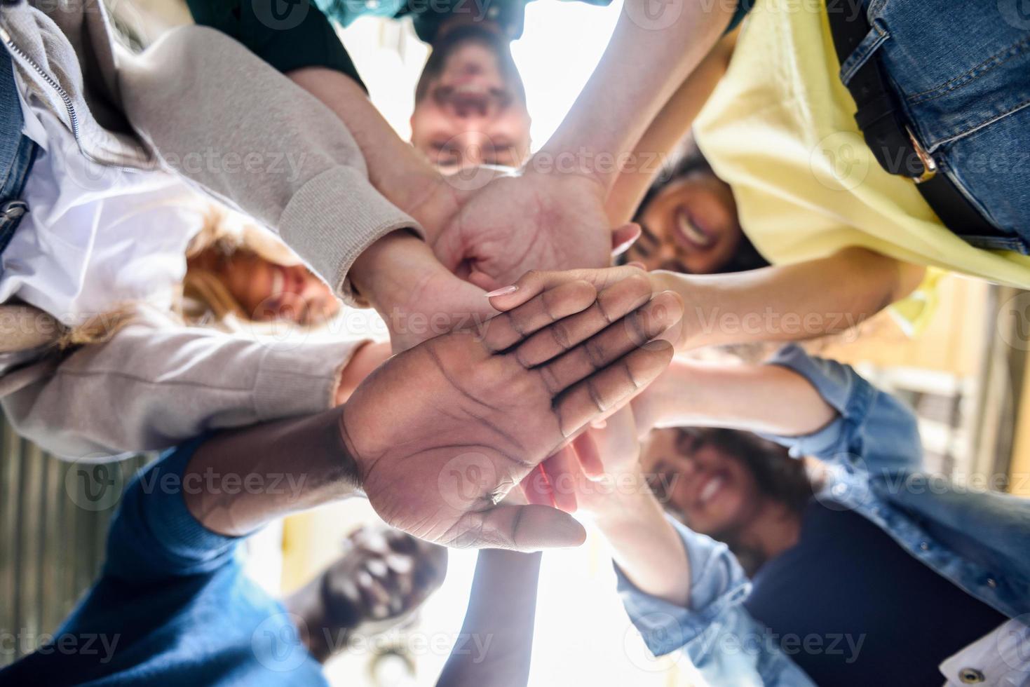 Young people putting their hands together. photo