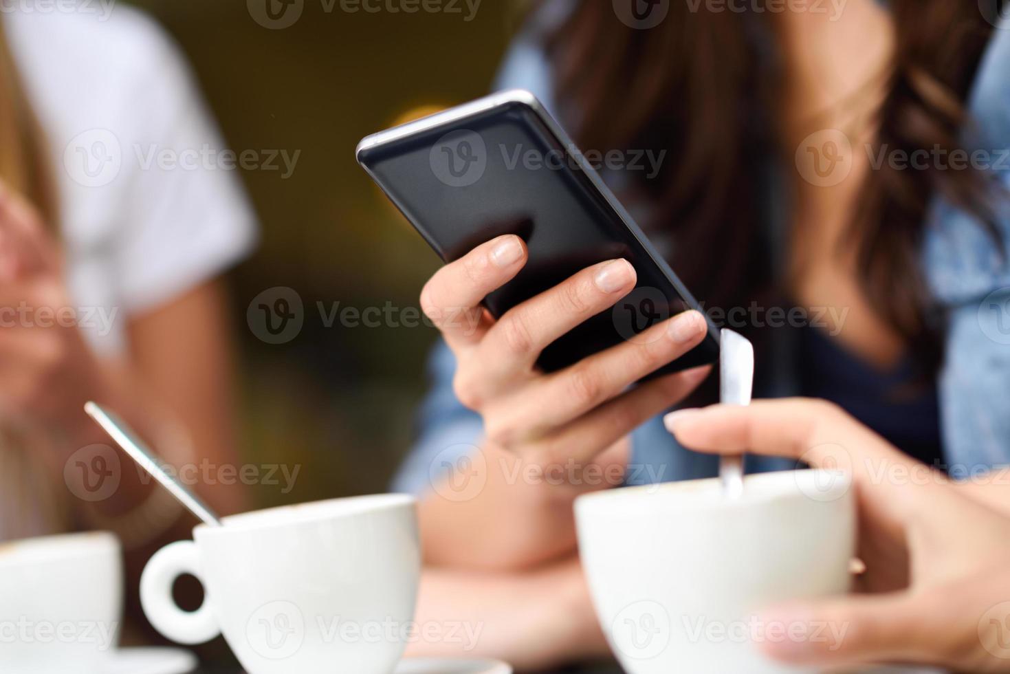 Young girl hand with modern smartphone device in cafe bar photo